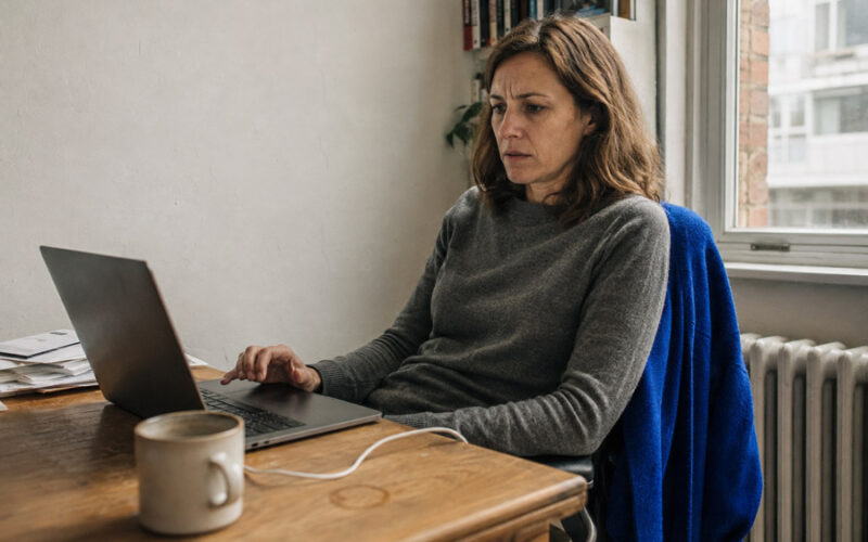 Woman at a home office desk looking at her laptop after a failed password login attempt.
