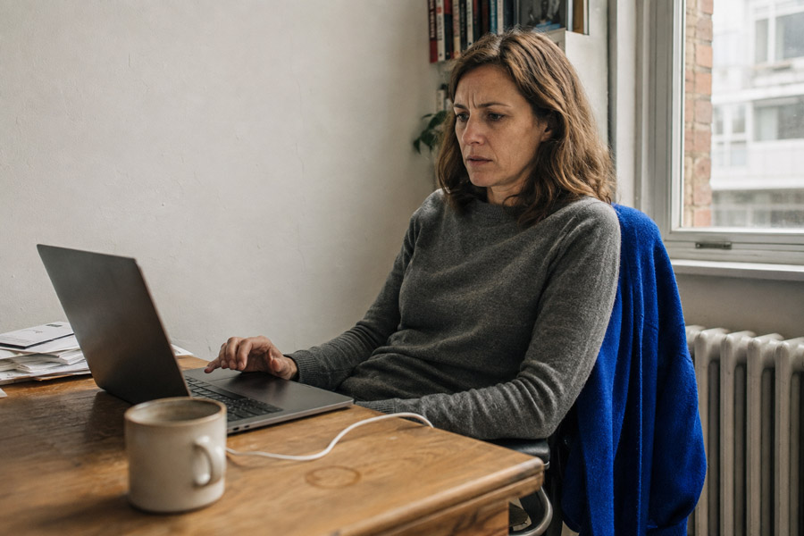 Woman at a home office desk looking at her laptop after a failed password login attempt.
